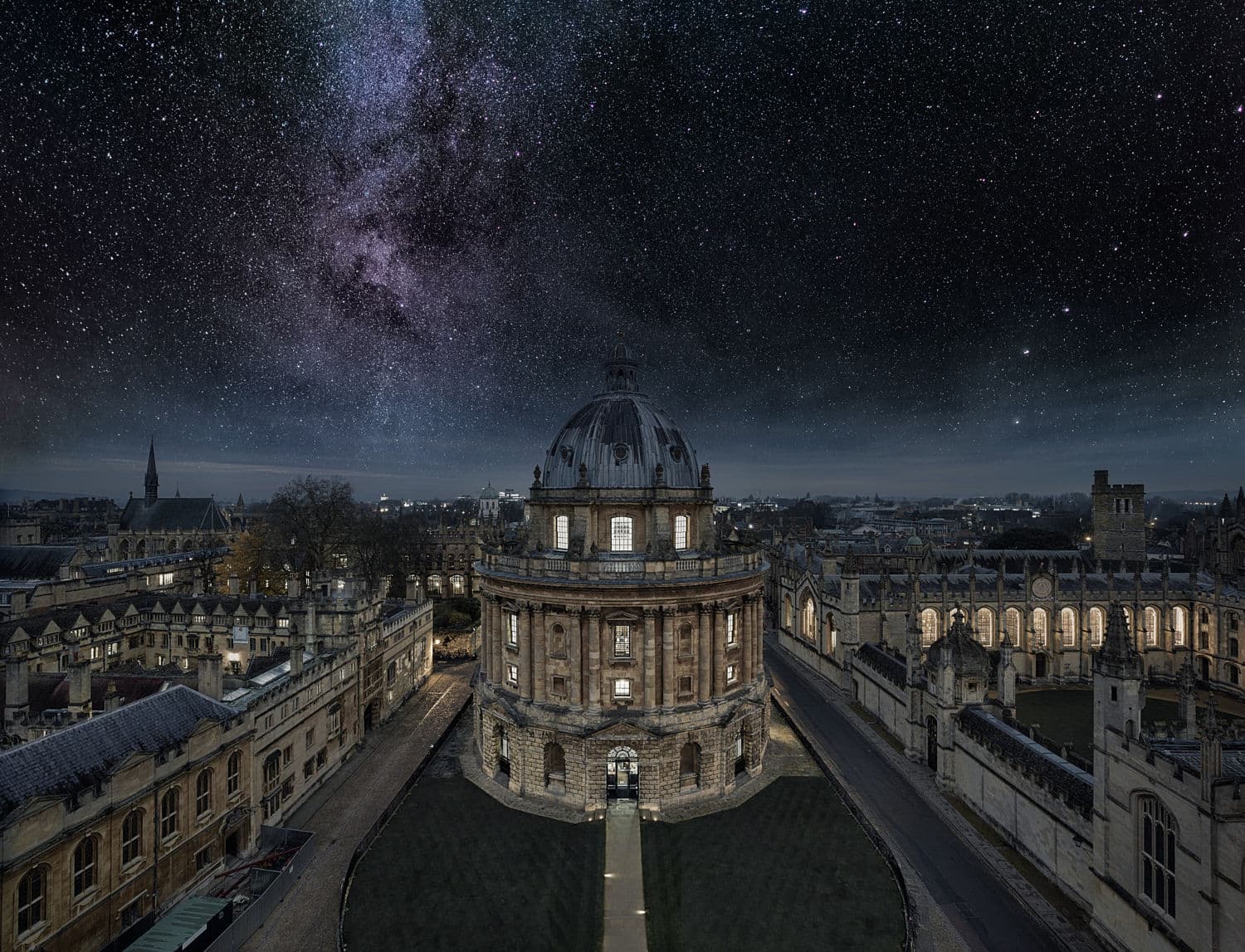 Görüntü, Oxford Üniversitesi Bodleian Kütüphanesi'nin bir parçası olan Radcliffe Camera'nın gece hava görüntüsünü, arka planda yıldızlı gökyüzü ve Samanyolu ile birlikte göstermektedir.